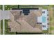 Aerial view showcasing a tiled roof, solar panels, pool, fenced yard, and patio furniture at 29043 Picana Ln, Wesley Chapel, FL 33543