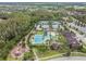 An aerial view of the community pool, clubhouse, tennis courts, playground and surrounding landscape at 29043 Picana Ln, Wesley Chapel, FL 33543