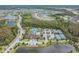 An aerial view of a luxurious community pool, tennis courts, and clubhouse next to a beautiful pond at 29043 Picana Ln, Wesley Chapel, FL 33543