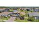 Overhead view of a blue home surrounded by palm trees and green lawns, near a serene lake at 29043 Picana Ln, Wesley Chapel, FL 33543