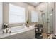 Luxurious bathroom with a soaking tub, a frameless glass shower, and elegant tile work at 29043 Picana Ln, Wesley Chapel, FL 33543