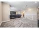 Bonus room with projector screen, leather sofa, and view of the stairs at 29043 Picana Ln, Wesley Chapel, FL 33543