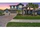 Beautiful two-story home featuring a stone facade, tile roof, three-car garage, and well-manicured landscaping at 29043 Picana Ln, Wesley Chapel, FL 33543