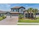 Beautiful two-story home featuring a stone facade, tile roof, three-car garage, and well-manicured landscaping at 29043 Picana Ln, Wesley Chapel, FL 33543