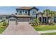 Beautiful two-story home featuring a stone facade, tile roof, three-car garage, and well-manicured landscaping at 29043 Picana Ln, Wesley Chapel, FL 33543