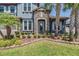 Charming home exterior featuring stone accents, a tiled roof, lush landscaping, and a welcoming entrance at 29043 Picana Ln, Wesley Chapel, FL 33543