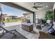 Spacious covered patio with comfortable seating, a fire pit, and a view of the pool and surrounding landscape at 29043 Picana Ln, Wesley Chapel, FL 33543