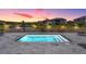 A serene pool area at sunset, surrounded by lush landscaping and neighborhood views at 29043 Picana Ln, Wesley Chapel, FL 33543