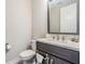 Stylish powder room featuring modern fixtures, a sleek vanity, and a mirror at 29043 Picana Ln, Wesley Chapel, FL 33543