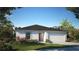 Charming single-story home with a two-car garage, landscaped front yard, and a welcoming red front door at 28166 S Twin Lakes Dr, Punta Gorda, FL 33955