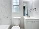 Clean bathroom with white fixtures, including a vanity, mirror, and tiled walls around the tub at 8231 Riverside Ne Dr, St Petersburg, FL 33702