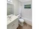 Clean, all-white bathroom featuring a tub and shower, a modern vanity, and a window at 1736 Taylor Lake Pl, Largo, FL 33778
