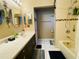 Bathroom featuring a vanity with sink, oval mirrors and a shower with tile accents at 3565 E Lake Dr, Land O Lakes, FL 34639
