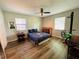A cozy bedroom with a ceiling fan, window blinds for privacy, and wood flooring, creating a comfortable space at 3565 E Lake Dr, Land O Lakes, FL 34639
