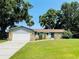Charming single-story home with stone accents, lush lawn, mature trees and a two car garage at 3565 E Lake Dr, Land O Lakes, FL 34639