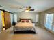 Serene main bedroom featuring a ceiling fan, natural light, and a stylish barn door to the bathroom at 3565 E Lake Dr, Land O Lakes, FL 34639