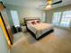 Spacious main bedroom featuring a ceiling fan, bright windows and a sliding barn door at 3565 E Lake Dr, Land O Lakes, FL 34639