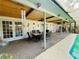 This covered patio features an outdoor dining area, ideal for entertaining, beside a sparkling swimming pool at 3565 E Lake Dr, Land O Lakes, FL 34639