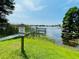 A picturesque view of the waterfront with a viewing dock and aquatic plants at 3565 E Lake Dr, Land O Lakes, FL 34639