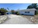 Single story home with white painted facade, long driveway, attached garage, and tidy landscaping at 4719 Alcazar S Way, St Petersburg, FL 33712
