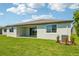 Inviting backyard featuring a covered patio, lush green lawn, and a modern light gray exterior at 1780 Draughton Dr, Zephyrhills, FL 33541