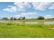 Expansive backyard with lush green grass, serene water view, and a picturesque tree line at 1780 Draughton Dr, Zephyrhills, FL 33541