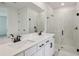 Bathroom featuring double sinks, sleek fixtures, and a walk-in shower with clear glass doors at 1780 Draughton Dr, Zephyrhills, FL 33541