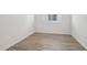 Bright bedroom with wood-look tile flooring and natural light from a window at 1780 Draughton Dr, Zephyrhills, FL 33541