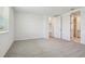 Comfortable bedroom with neutral carpet and a door leading to an attached bathroom, enhanced by natural light at 1780 Draughton Dr, Zephyrhills, FL 33541