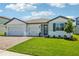 Beautiful single-Gathering home with a well-maintained lawn, a brick driveway, and a three-car garage at 1780 Draughton Dr, Zephyrhills, FL 33541