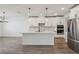 Bright kitchen featuring an island, white cabinets, stainless steel appliances, and modern pendant lighting at 1780 Draughton Dr, Zephyrhills, FL 33541