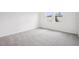 Empty bedroom with plush carpeting and a bright window with natural light at 1828 Brekey Way, Zephyrhills, FL 33541