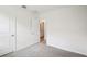 A clean, empty bedroom features two doors and carpeted floors for your personalization at 1828 Brekey Way, Zephyrhills, FL 33541