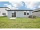 Back exterior view showing the home's patio, sliding glass doors and ample yard space at 1828 Brekey Way, Zephyrhills, FL 33541
