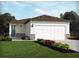 Charming single story home featuring a two car garage, stone veneer accents, and well manicured lawn at 1828 Brekey Way, Zephyrhills, FL 33541