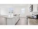 Modern kitchen with island, granite counters, stainless appliances, and sleek white cabinets at 1828 Brekey Way, Zephyrhills, FL 33541
