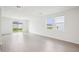 Bright, airy living room with sleek tile flooring and sliding glass doors at 1828 Brekey Way, Zephyrhills, FL 33541