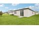A well-maintained backyard featuring lush green grass and a view of the home's exterior and surrounding properties at 1847 Brekey Way, Zephyrhills, FL 33541