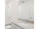 Bright bathroom with a granite countertop, a large mirror, and a shower with white tiling at 1847 Brekey Way, Zephyrhills, FL 33541