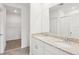 Bathroom with double vanity, granite counters, tile floors, and walk-in closet access at 1847 Brekey Way, Zephyrhills, FL 33541