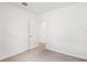 Bedroom with neutral carpet and one open door with tile floors in the background at 1847 Brekey Way, Zephyrhills, FL 33541