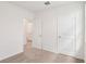 Bedroom with neutral carpet, two doors and one open door with tile floors in the background at 1847 Brekey Way, Zephyrhills, FL 33541