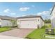 A two-car garage with a brick-paved driveway, enhancing the curb appeal of the home's exterior at 1847 Brekey Way, Zephyrhills, FL 33541