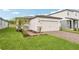 Two-car garage with brick paver driveway, complemented by landscaped greenery enhancing curb appeal at 1847 Brekey Way, Zephyrhills, FL 33541