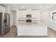 Modern kitchen with stainless steel appliances, white cabinets, and granite countertops on a central island at 1847 Brekey Way, Zephyrhills, FL 33541