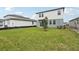 New construction home featuring a spacious green backyard with a young tree planted at 1855 Brekey Way, Zephyrhills, FL 33541