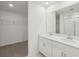 Bathroom featuring double vanities, a large mirror, and a walk-in shower at 1855 Brekey Way, Zephyrhills, FL 33541