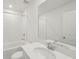 All-white bathroom with a bathtub, shower, and large vanity mirror at 1855 Brekey Way, Zephyrhills, FL 33541