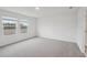 Spacious bedroom with plush carpeting and bright natural light from two large windows at 1855 Brekey Way, Zephyrhills, FL 33541