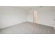 Minimalist bedroom with neutral carpet, white walls, and a doorway leading to another room at 1855 Brekey Way, Zephyrhills, FL 33541